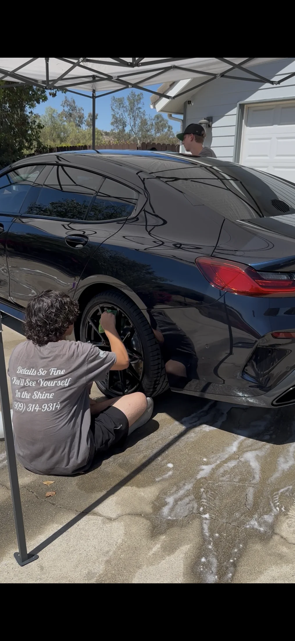 G&S detailer cleaning a black BMW at a customer location